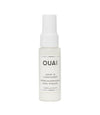 A white spray bottle labeled 'OUAI LEAVE IN CONDITIONER' with a clear measurement scale on the front.