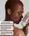 Close-up of a person with freckles and sun damage holding and pouring a translucent cleansing bottle against a light gray background, with three text callouts on the left describing the fragrance and cleansing benefits.