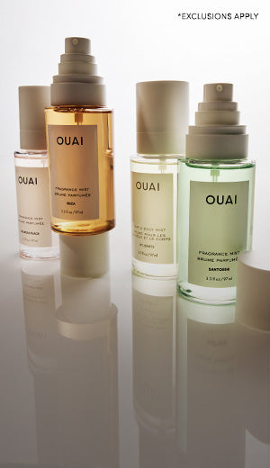 OUAI hair care products on a reflective surface with a white background