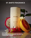 OUAI deodorant with dragon fruit, orange, and flowers on a reflective surface