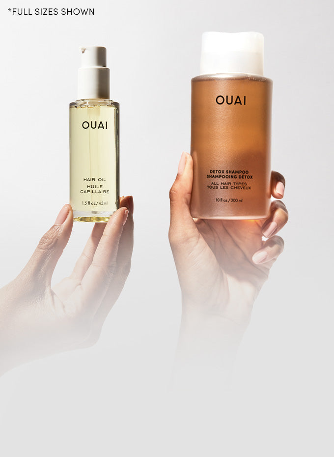 Two OUAI hair care products held by hands against a white background