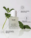 OUAI scalp serum bottle with green leaves on a white background