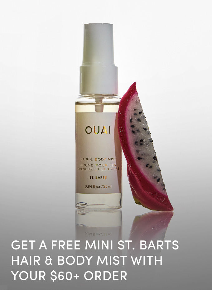 OUAI hair mist bottle with a dragon fruit slice on a reflective surface