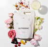 Detergent Pouch surrounded by flowers and berries
