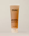 A travel-sized amber shampoo tube stands upright on a softly lit cream surface. Text: “OUAI”, “DETOX SHAMPOO”, “SHAMPOOING DÉTOX”, “ALL HAIR TYPES”, “TOUS LES CHEVEUX”, “1 fl oz / 30 ml”.