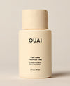 A travel-sized ivory OUAI Fine Hair Conditioner bottle stands upright against a softly lit cream background. Text: “OUAI”, “FINE HAIR”, “CHEVEUX FINS”, “CONDITIONER”, “REVITALISANT”, “3 fl oz / 89 ml”.