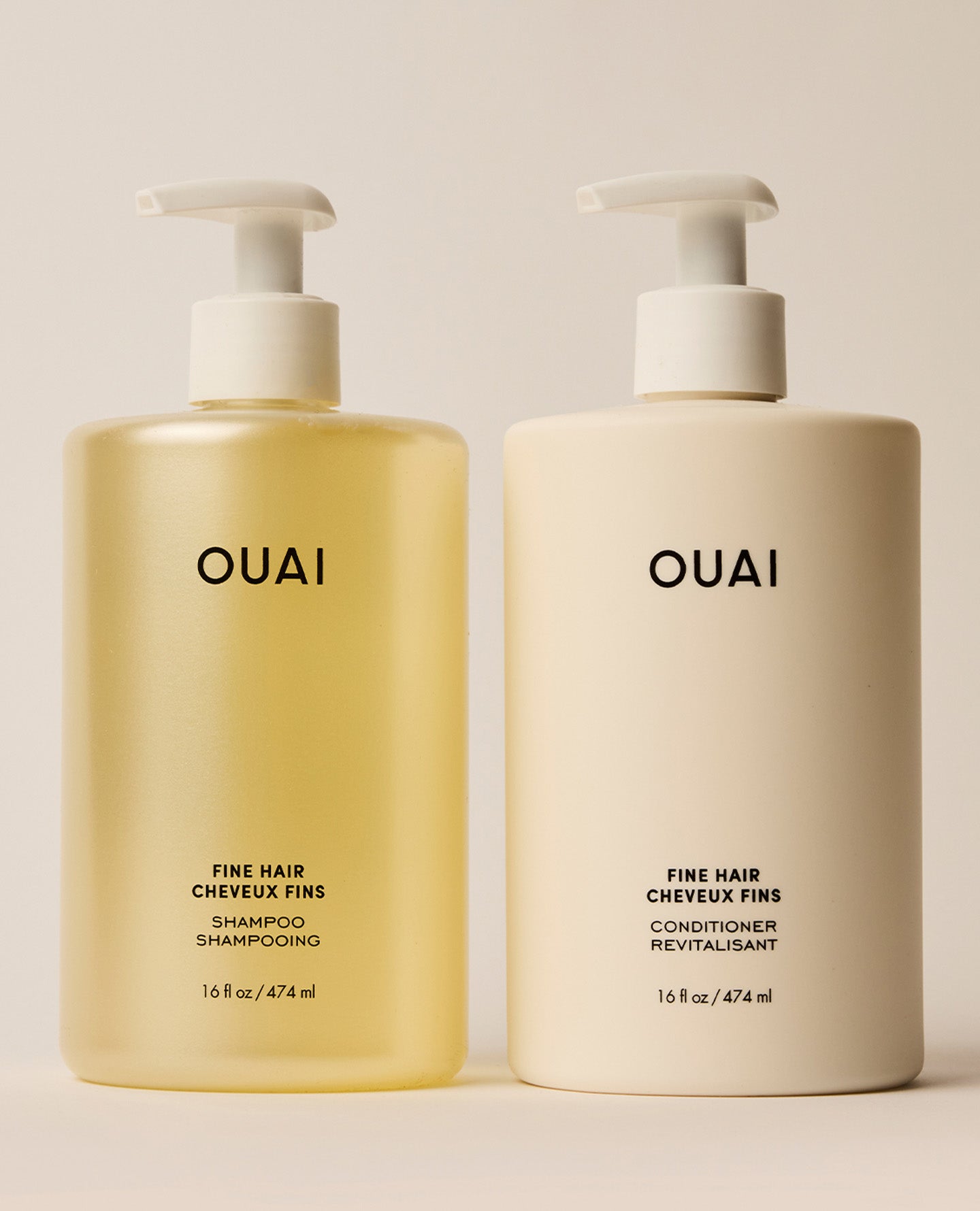 Two jumbo OUAI Fine Hair shampoo and conditioner pump bottles stand side by side, with pale yellow translucent shampoo and opaque ivory conditioner packaging.