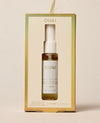 OUAI St. Bart's Hair & Body Mist in a clear glass spray bottle with a white pump, presented inside its cream-colored packaging box with gold borders.