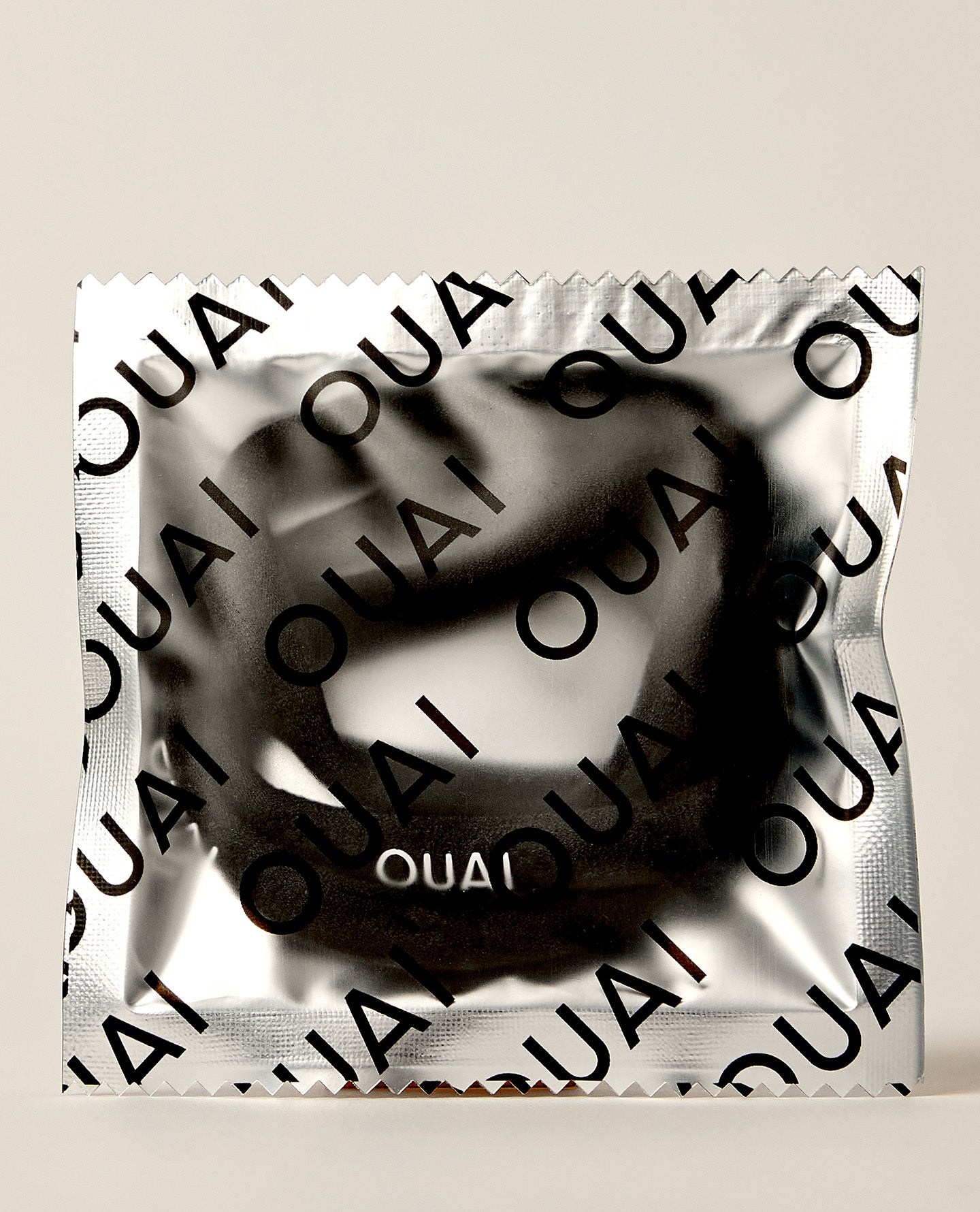 OUAI branded hair tie packaged in silver foil wrapper on neutral background.