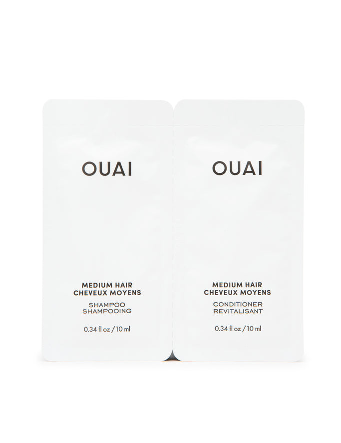 Two packets labeled 'OUAI' for Medium Hair Shampoo and Conditioner.